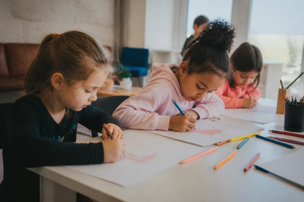 Enfants dessinant dans une salle de quartier lumineuse