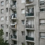 Hauts immeubles gris avec balcons et linge suspendu