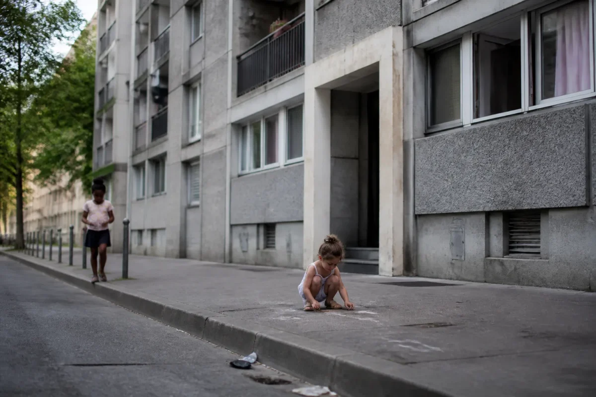 Grands immeubles gris et enfants jouant sur le trottoir
