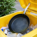 Poele metallique deposee dans bac recyclage jaune